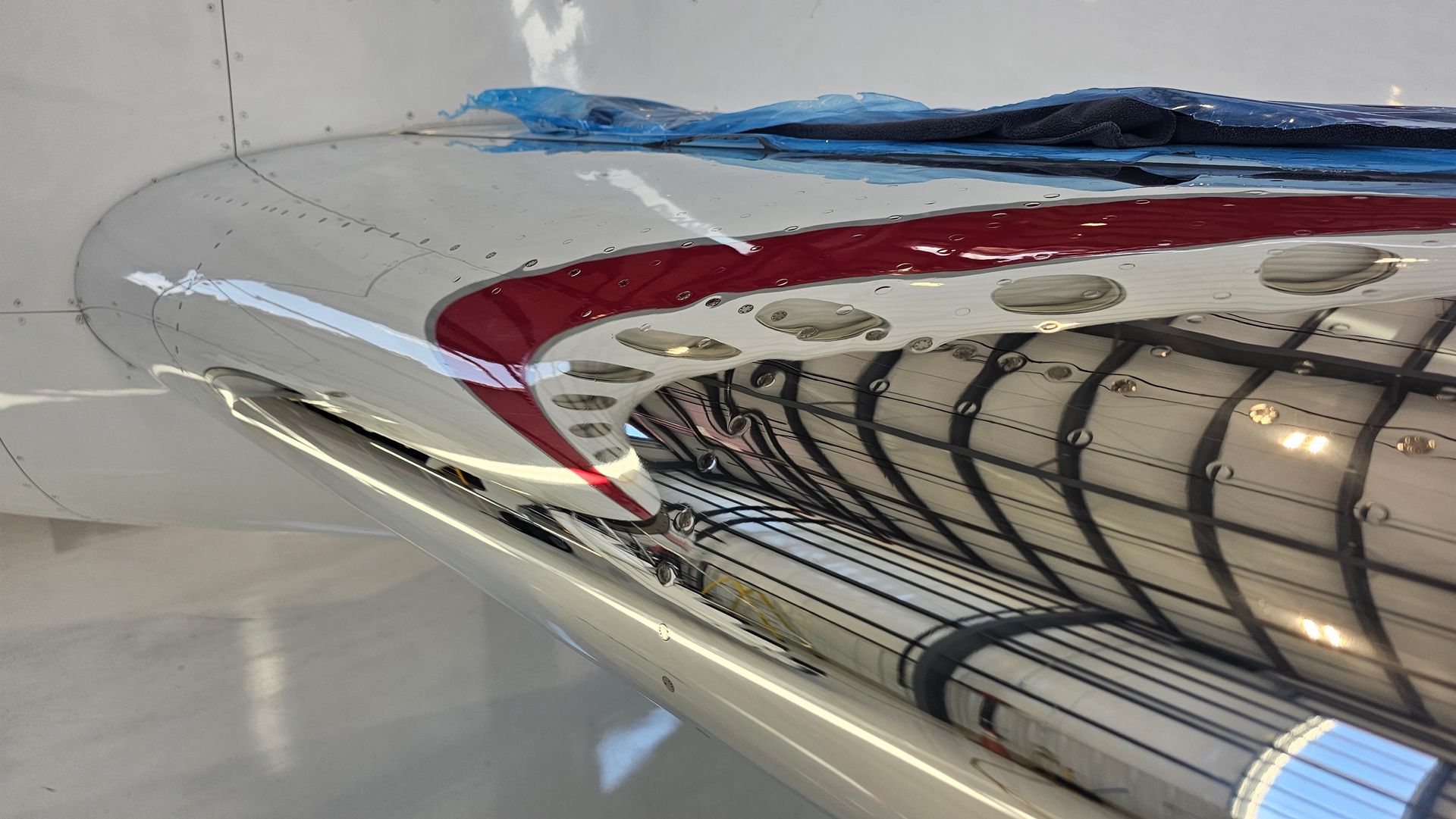 Wing interior of an aircraft, showing fuel tanks, structural supports, and red accent paint.