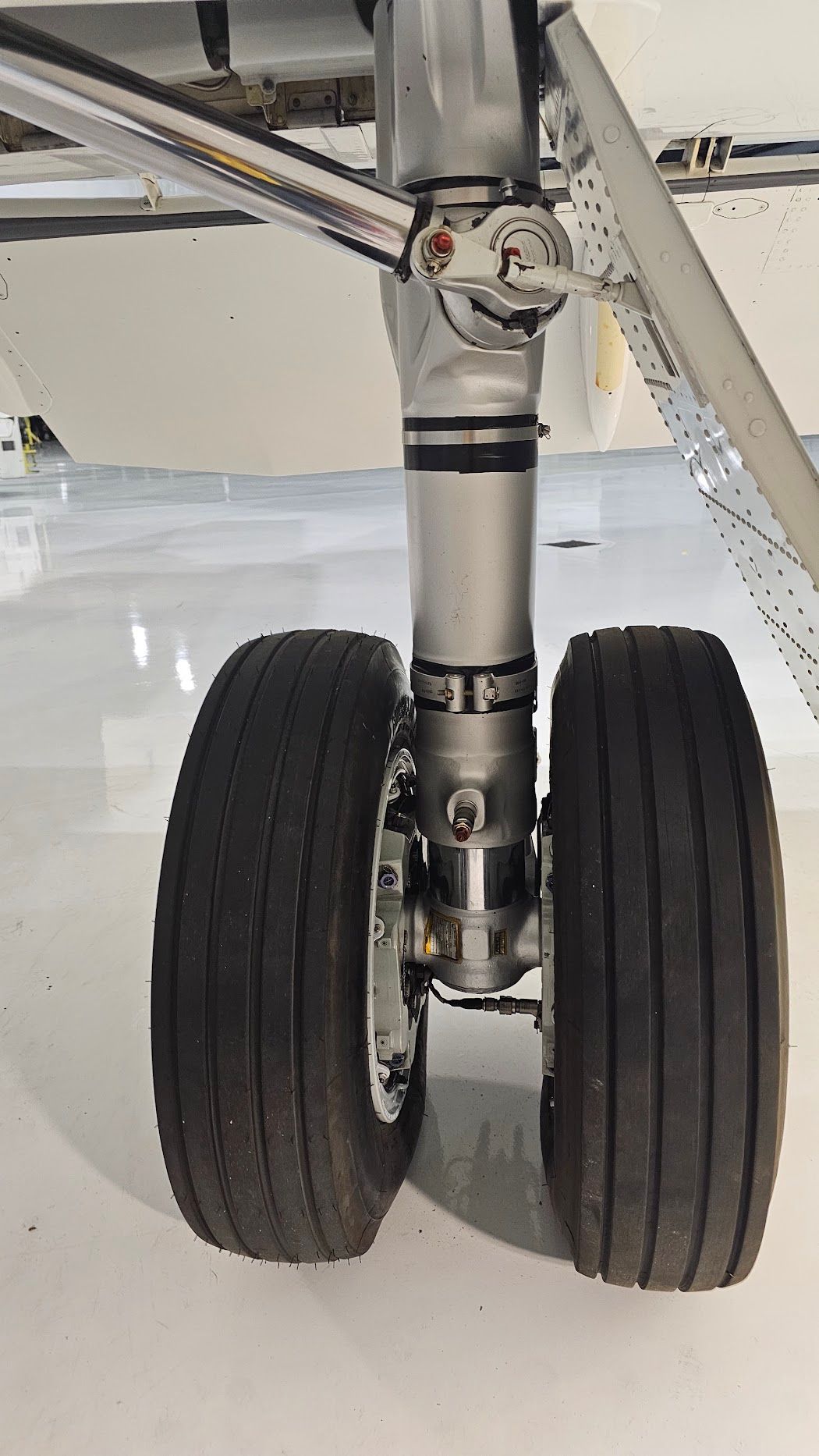 Aircraft landing gear with two tires and a silver strut.