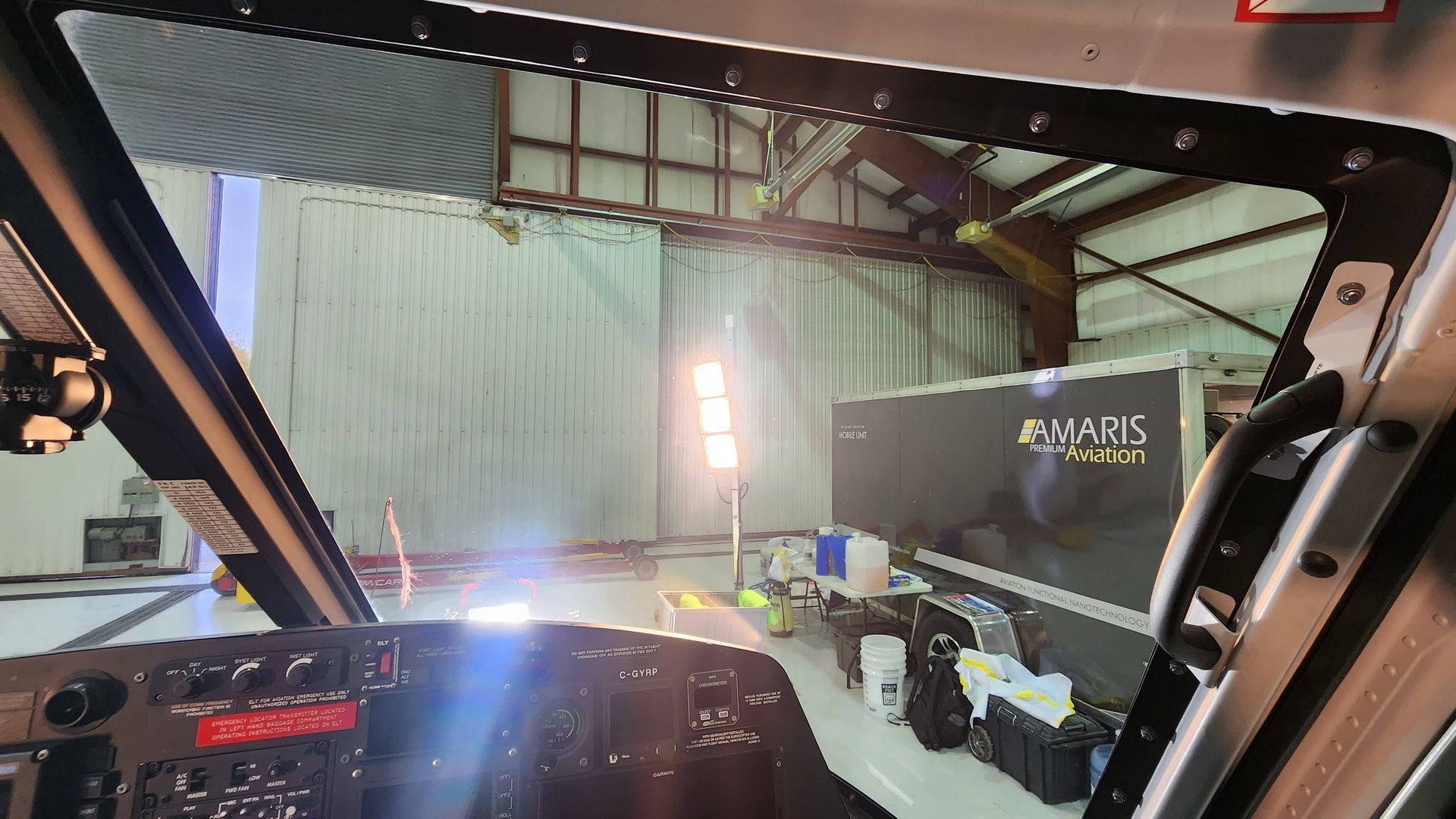 View from inside a cockpit looking out at a hangar, including a truck labeled