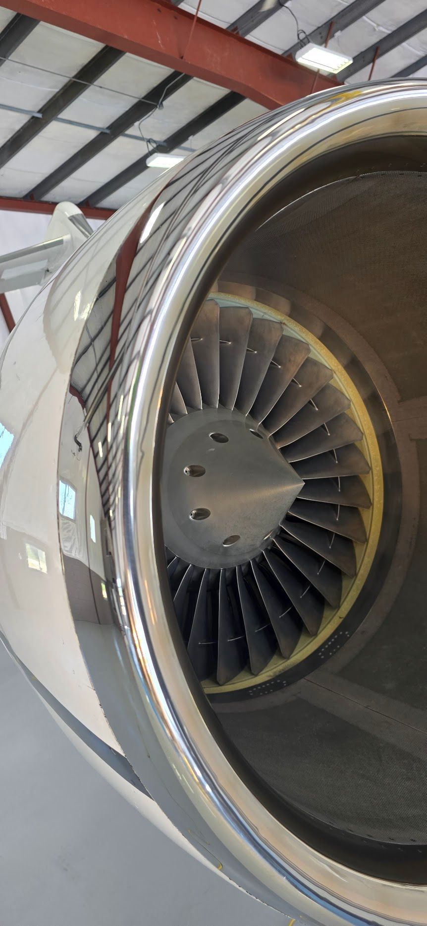 Close-up of a jet engine with visible turbine blades inside the engine's intake.