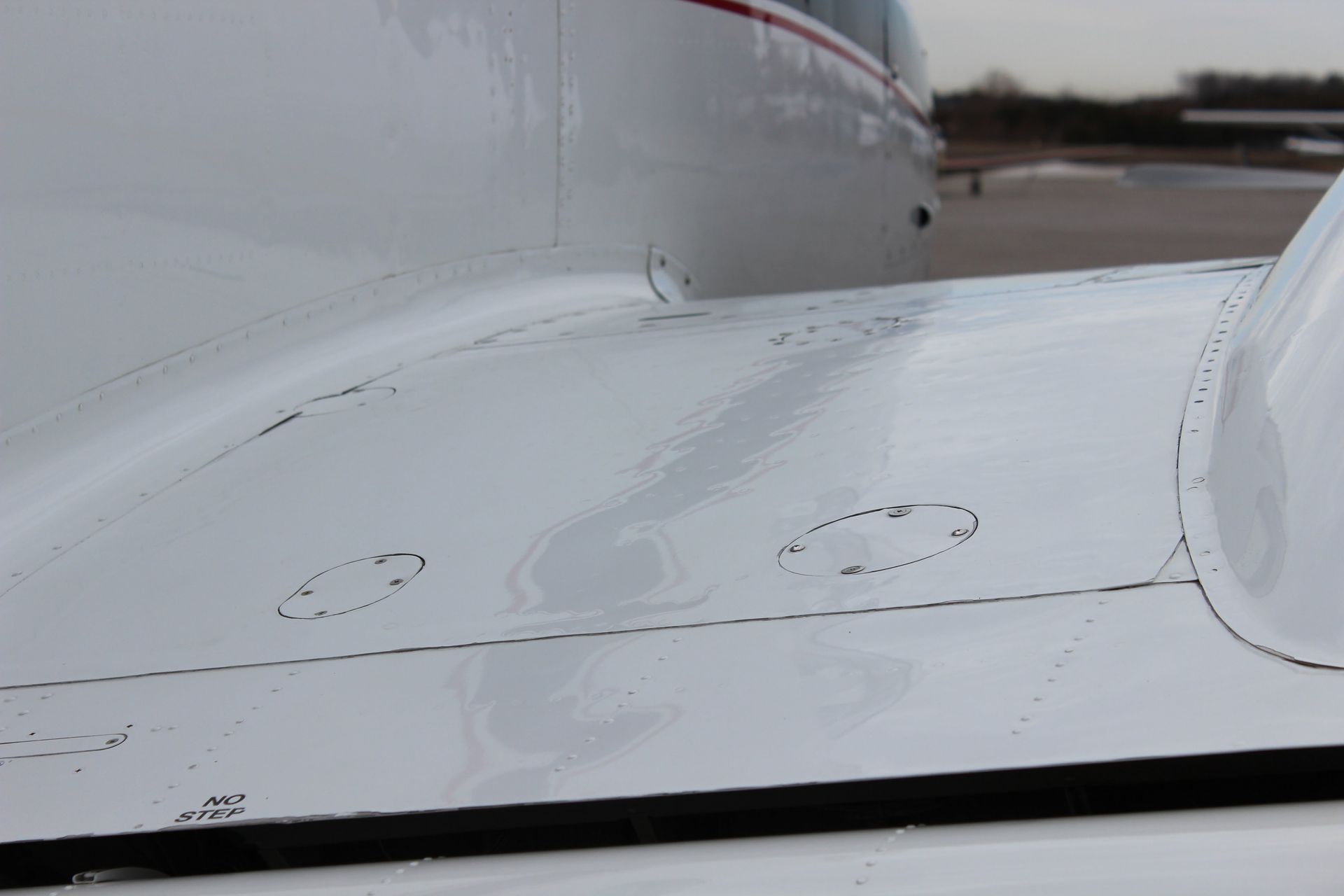 White airplane wing with circular inspection ports.