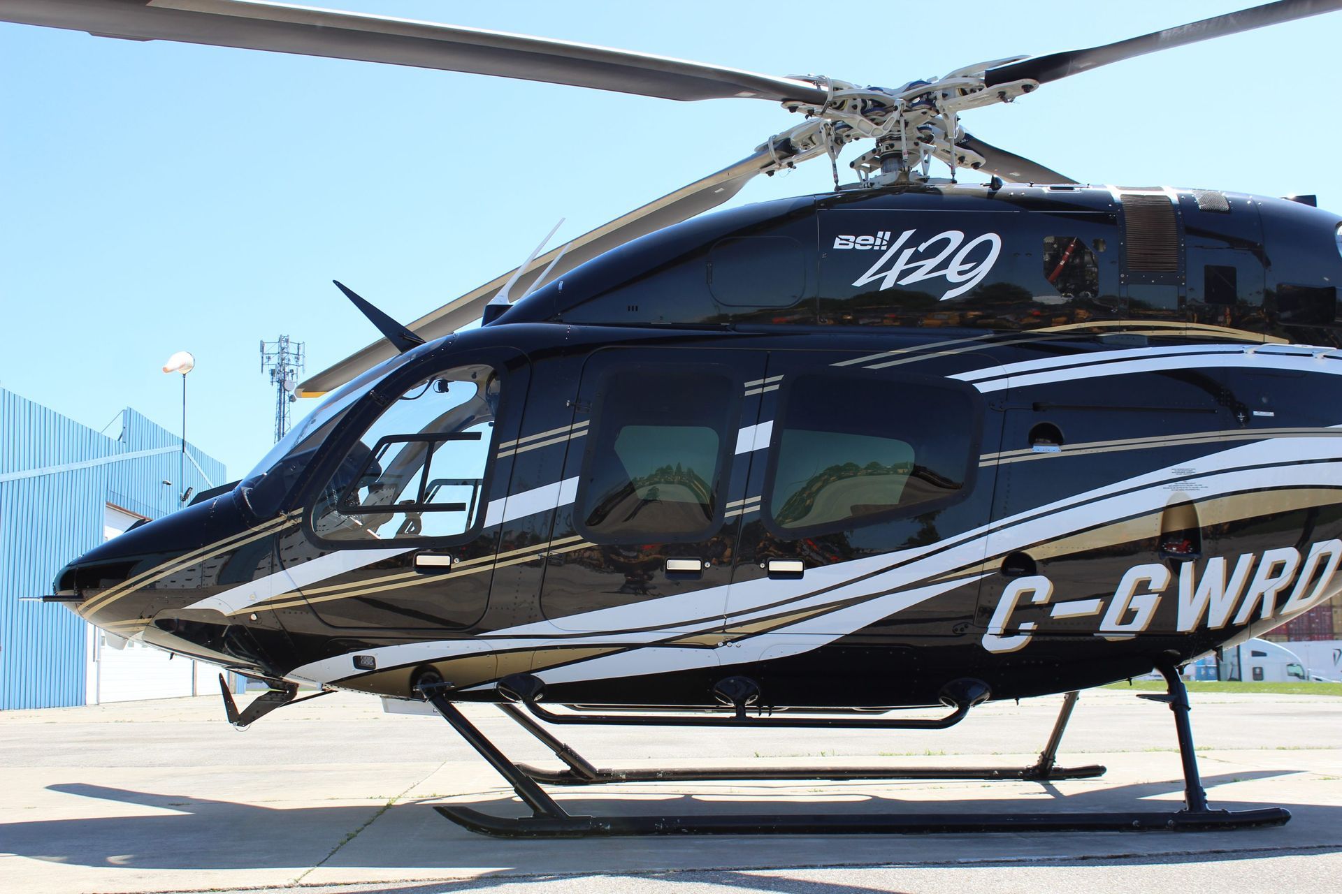 Black helicopter with white accents and registration C-GWRD on a tarmac.