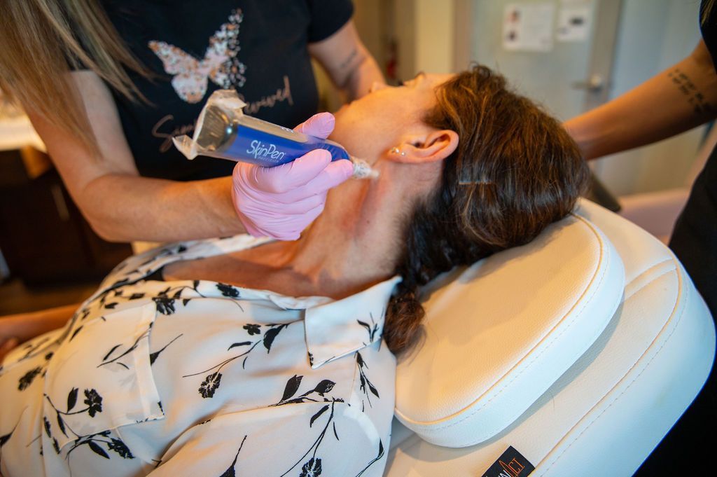 Person receiving a cosmetic procedure on their neck, held by two people.