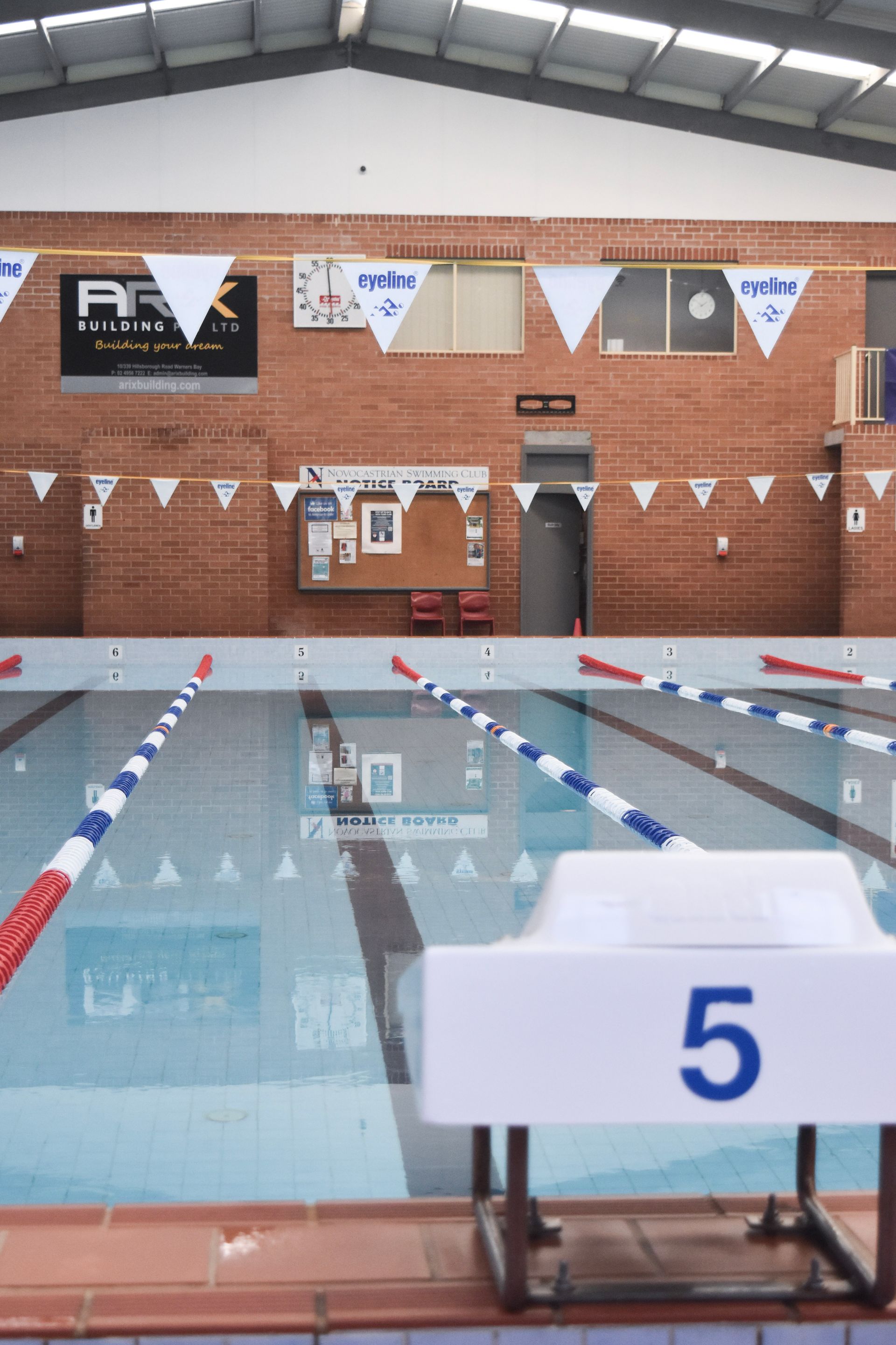 A swimming pool with the number 5 on the starting block