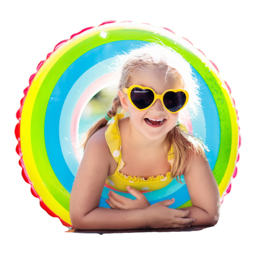 A little girl in a yellow bikini and heart shaped sunglasses is laying on a rainbow colored raft.