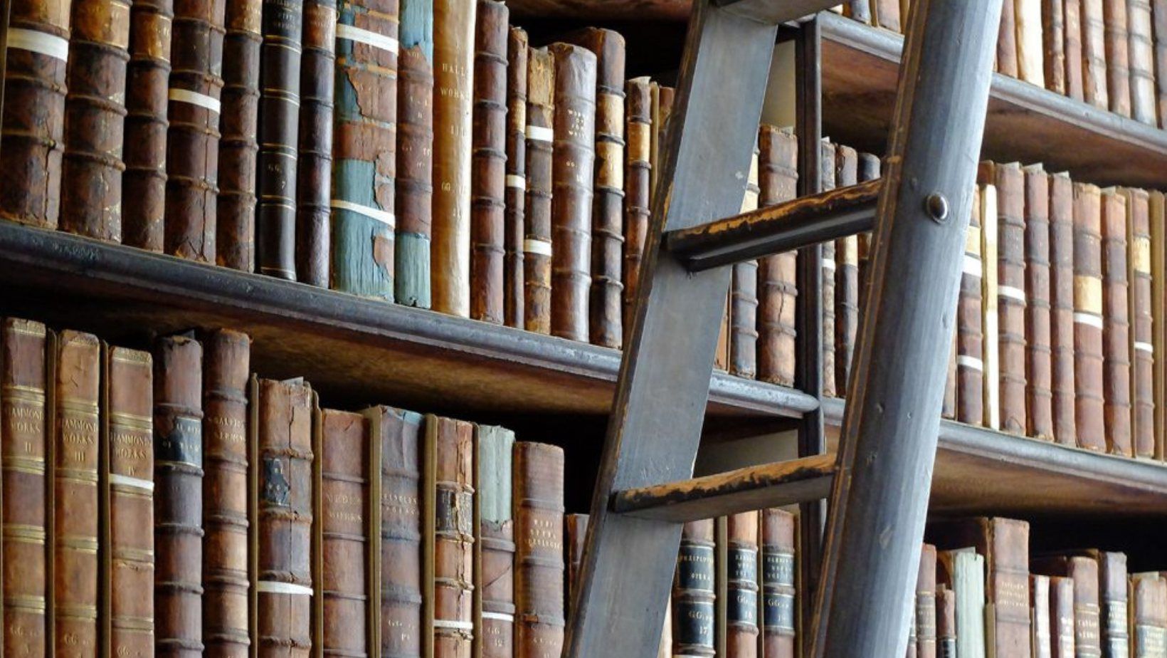 Una biblioteca piena di vecchi libri e una scala.