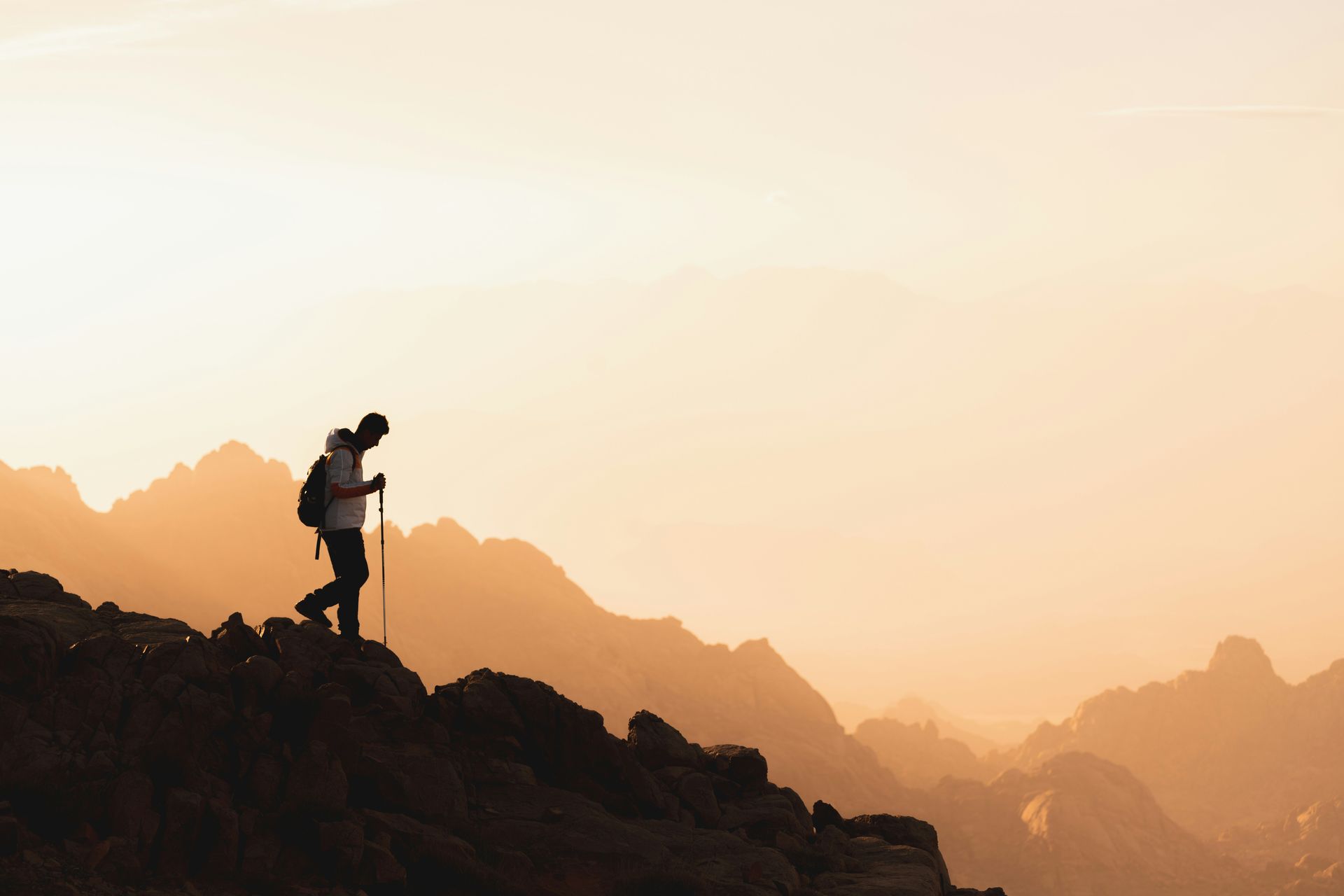 Photo of hiker traversing big rocks
