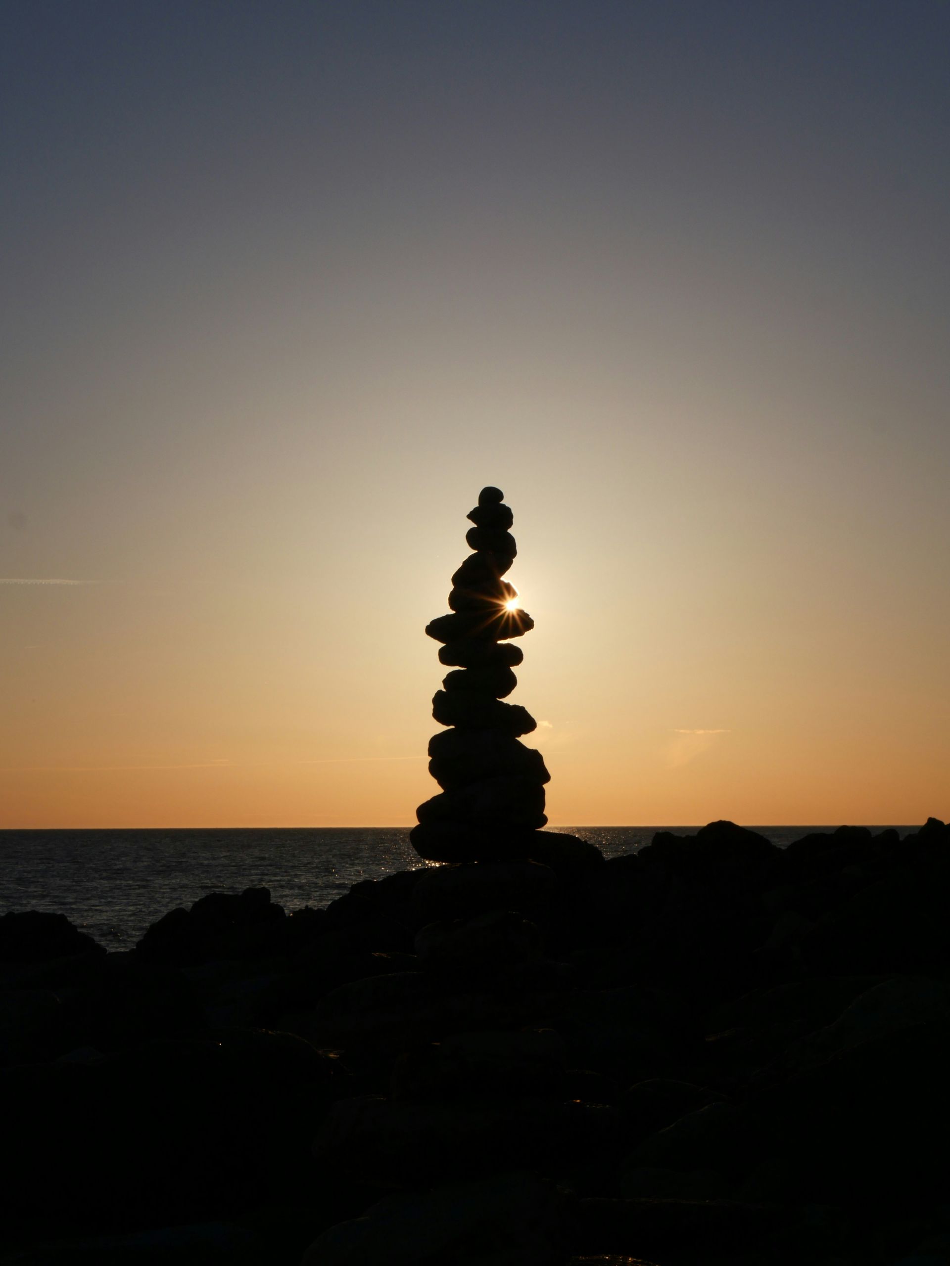 Silhouette of rocks balancing on top one another in the sunlight