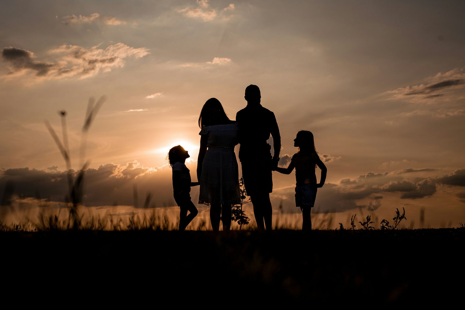 Silhouette of family holding hands