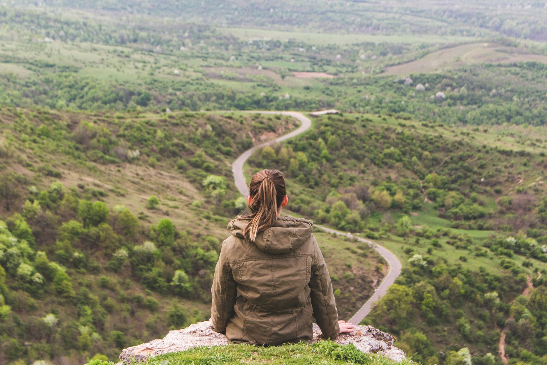 Photo of Caucasian woman looking into distance at winding path below