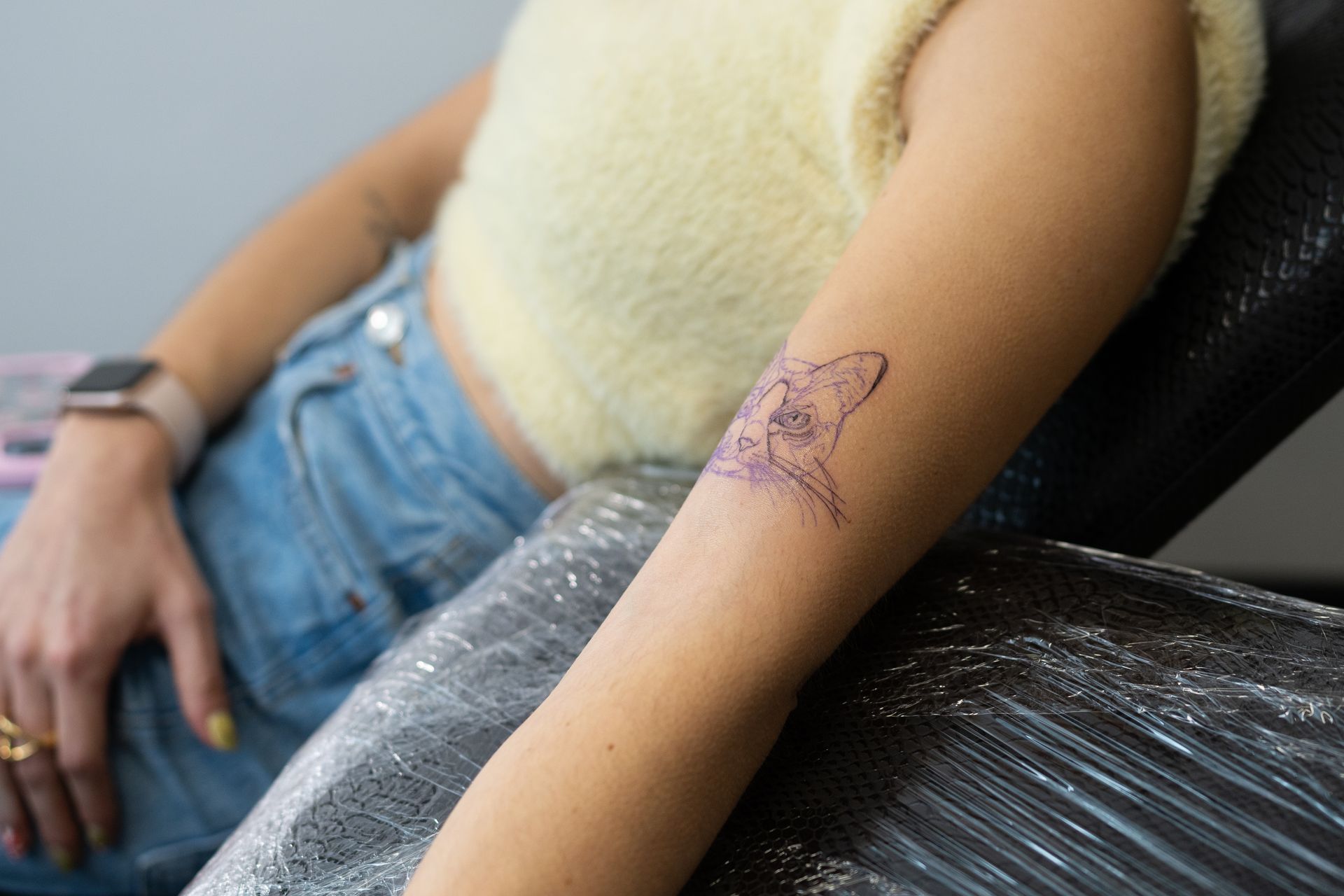 Person getting a shark tattoo on their arm.