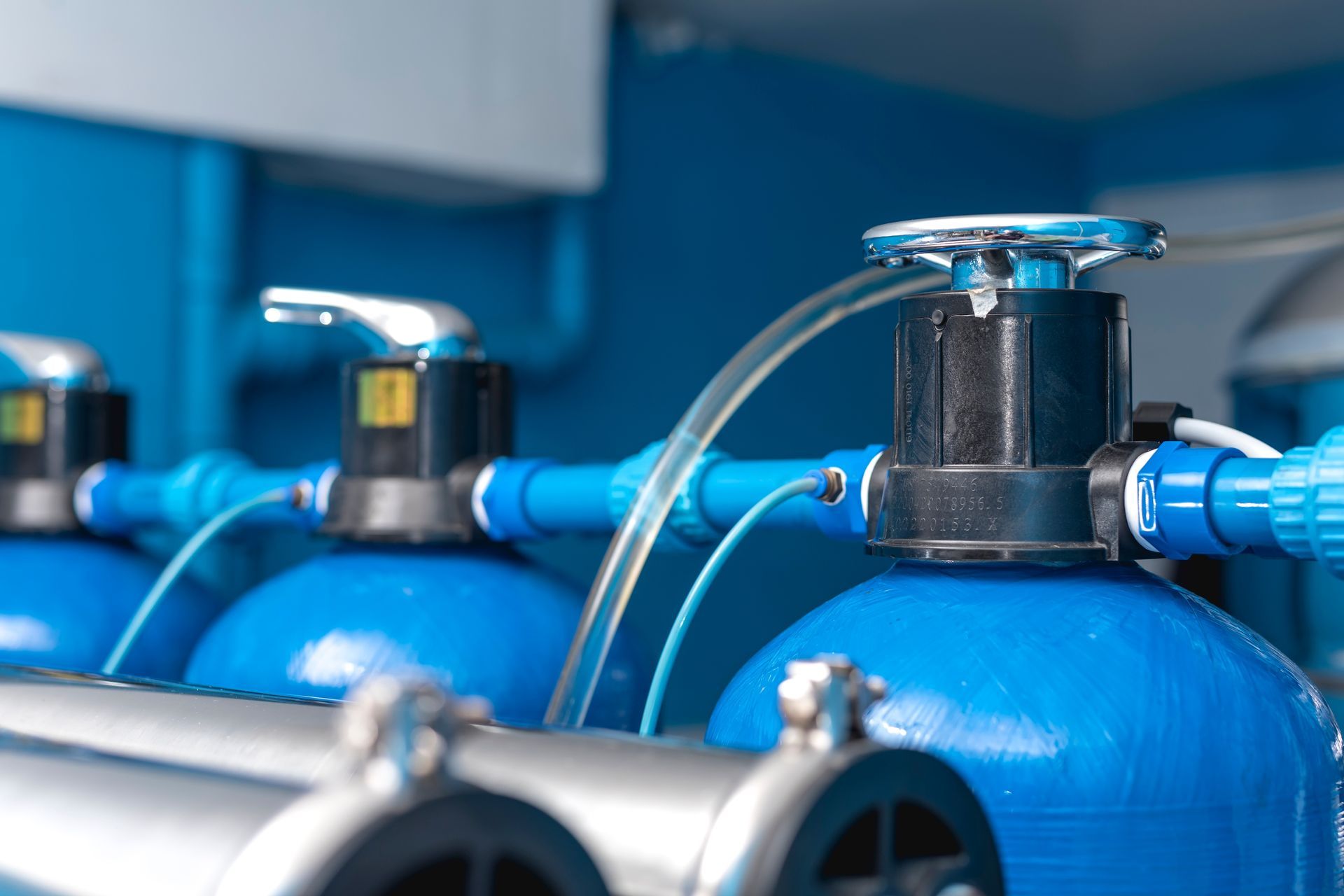 A close up of a row of blue pipes and valves