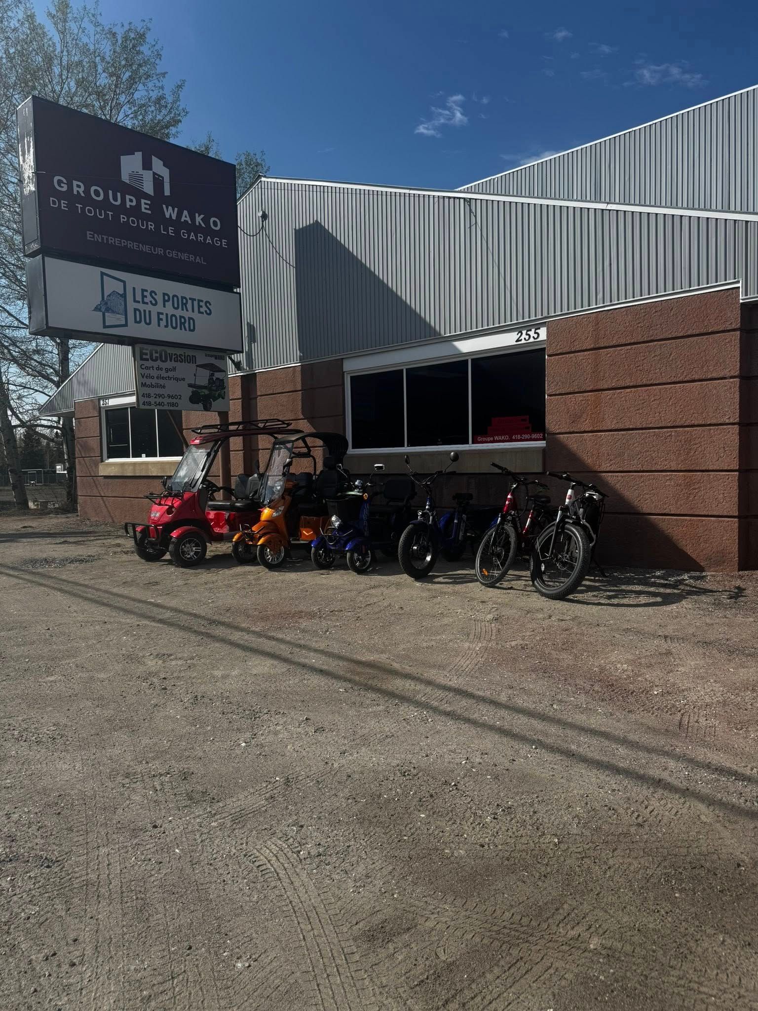 Une vitrine avec des voiturettes de golf et des vélos à vendre, sous un ciel bleu. L'enseigne indique « Sequoia Motors ».