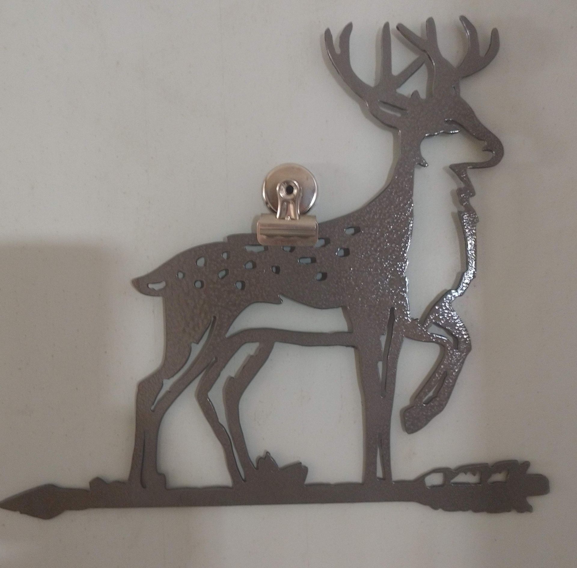 A silhouette of a deer with a clip on its back A silhouette of a deer with a clip on its back