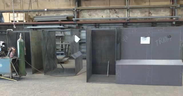 A man is welding a piece of metal in a factory.