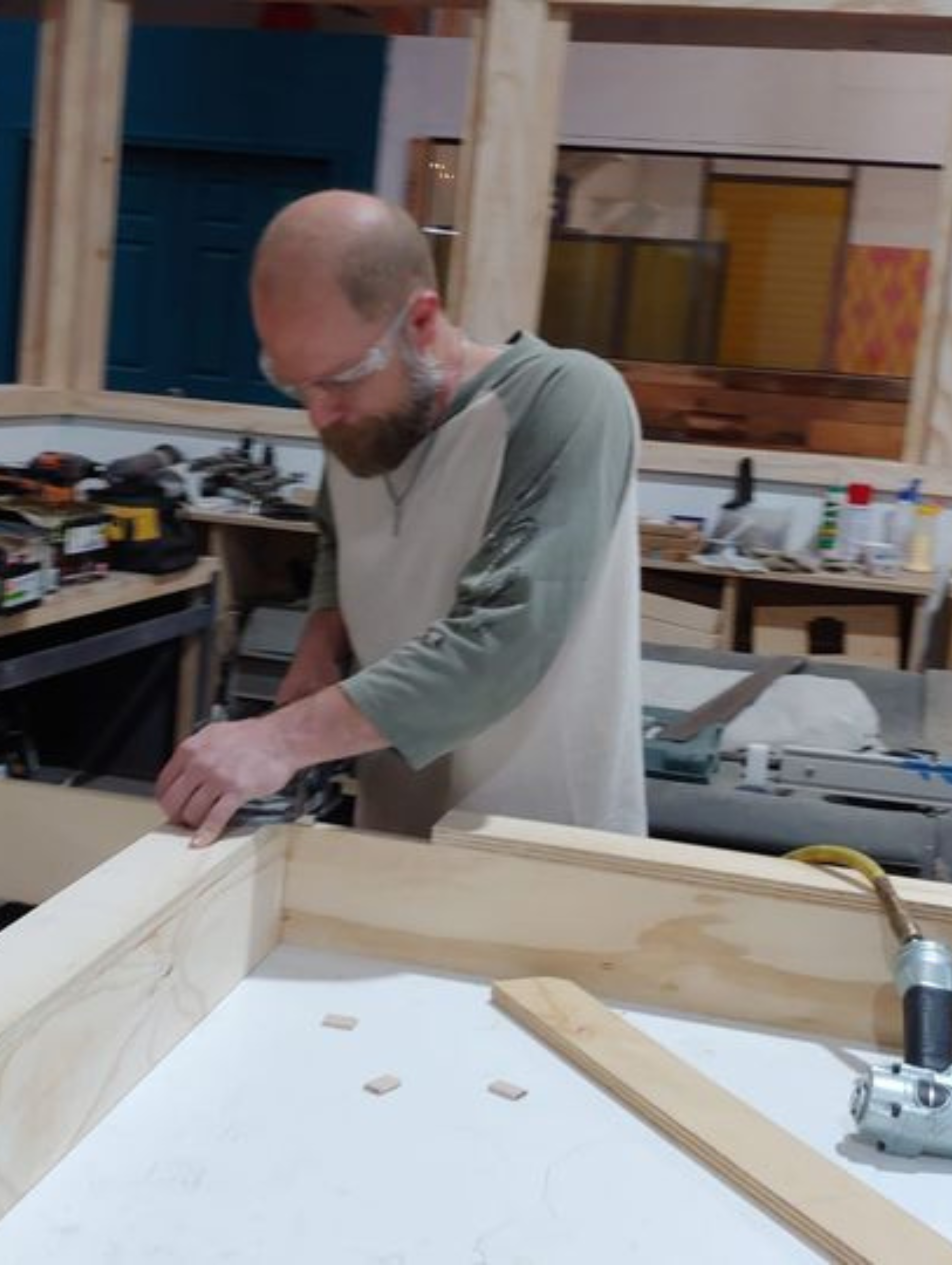 a man is working on a piece of wood in a workshop