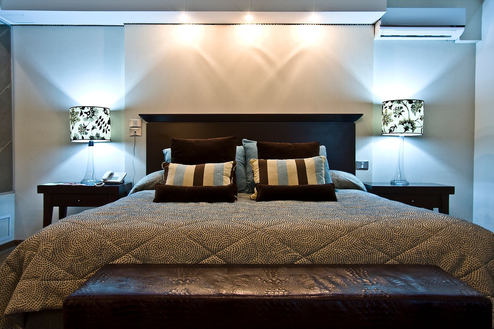 Una habitación de hotel con una cama grande y dos lámparas.