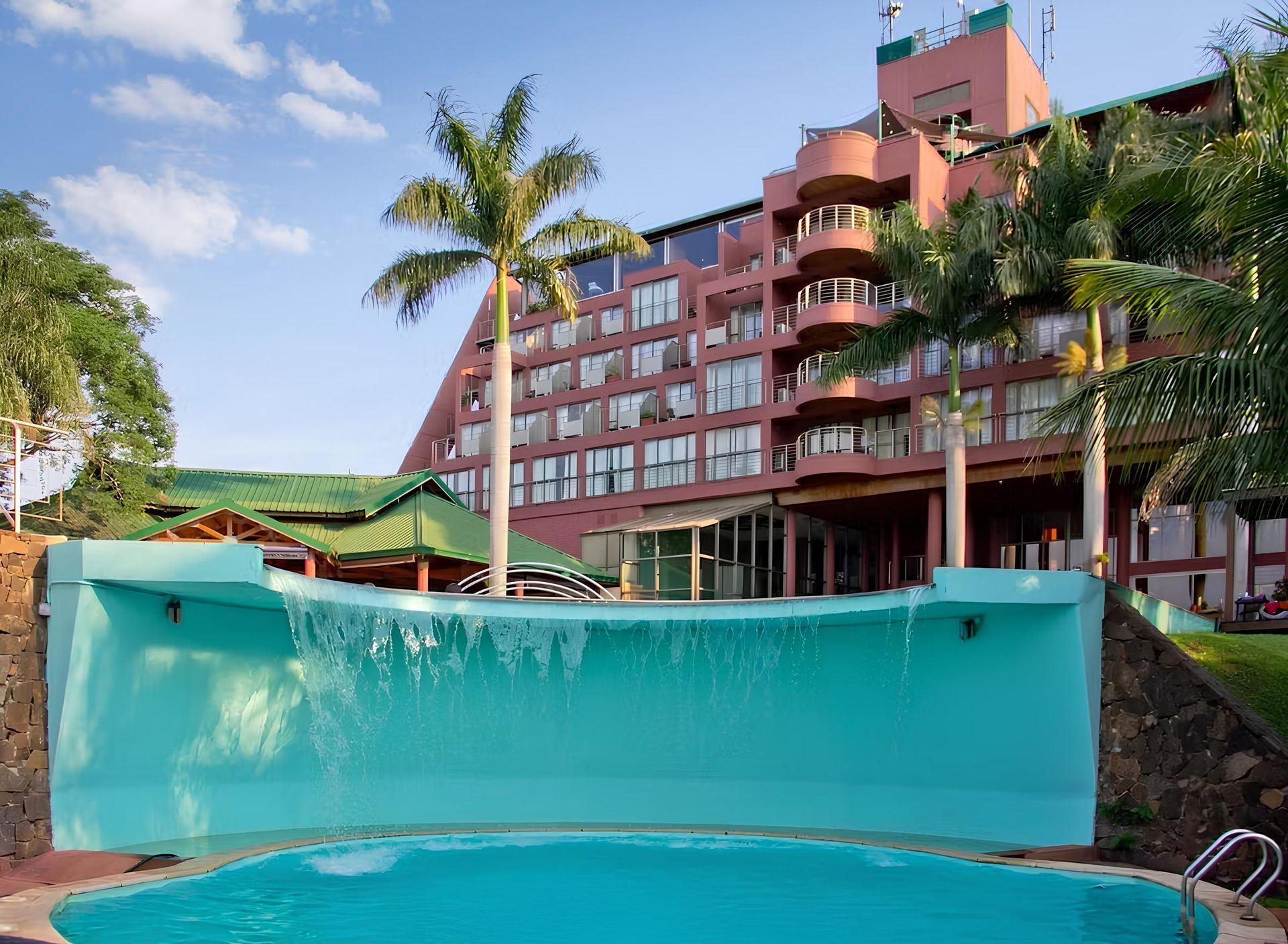 Un edificio grande con una piscina enfrente.