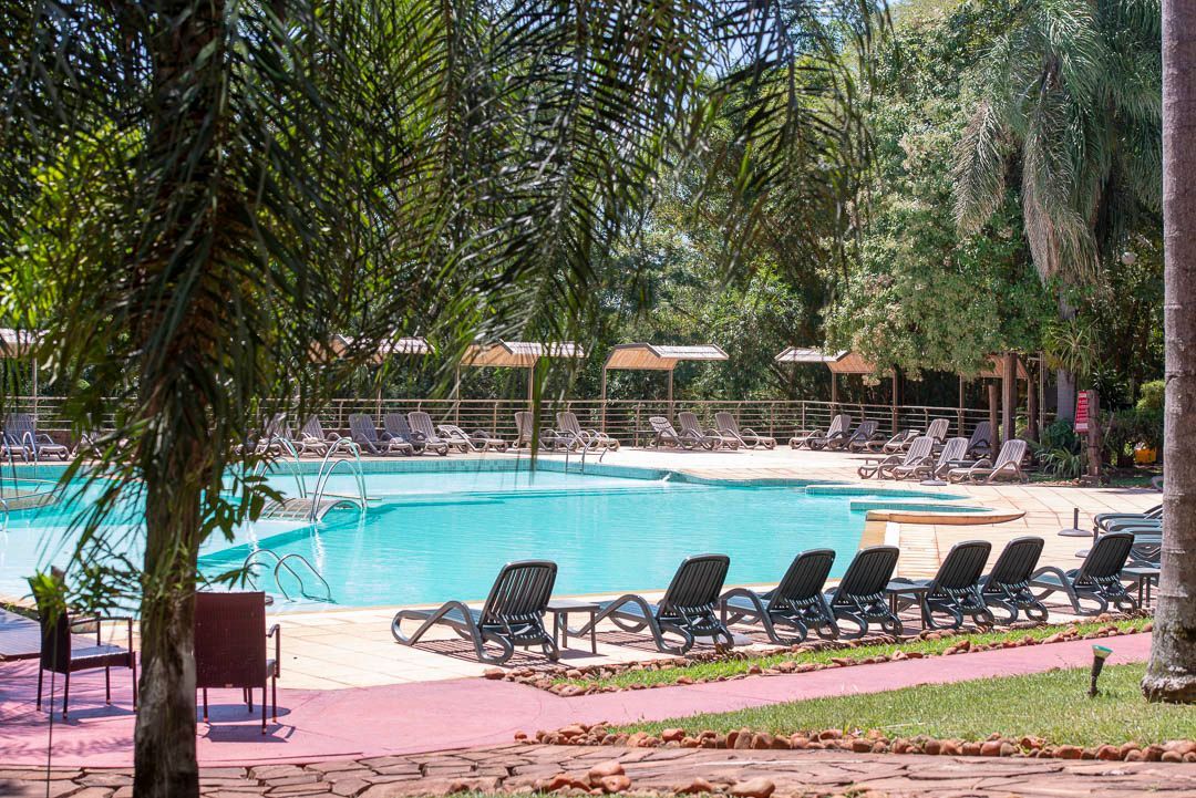 Una gran piscina rodeada de tumbonas y sombrillas.