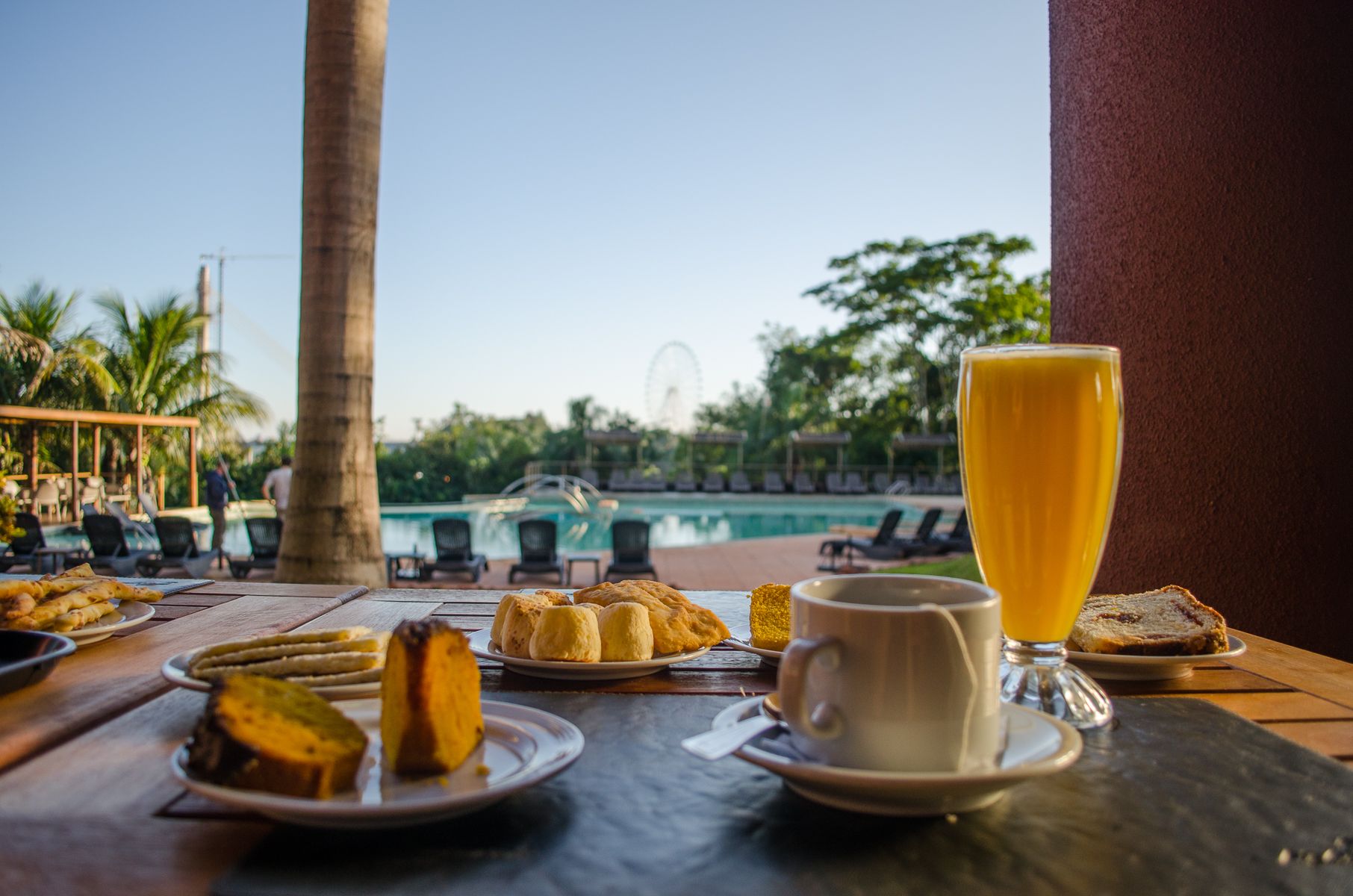 Una mesa cubierta con platos de comida y un vaso de zumo de naranja.