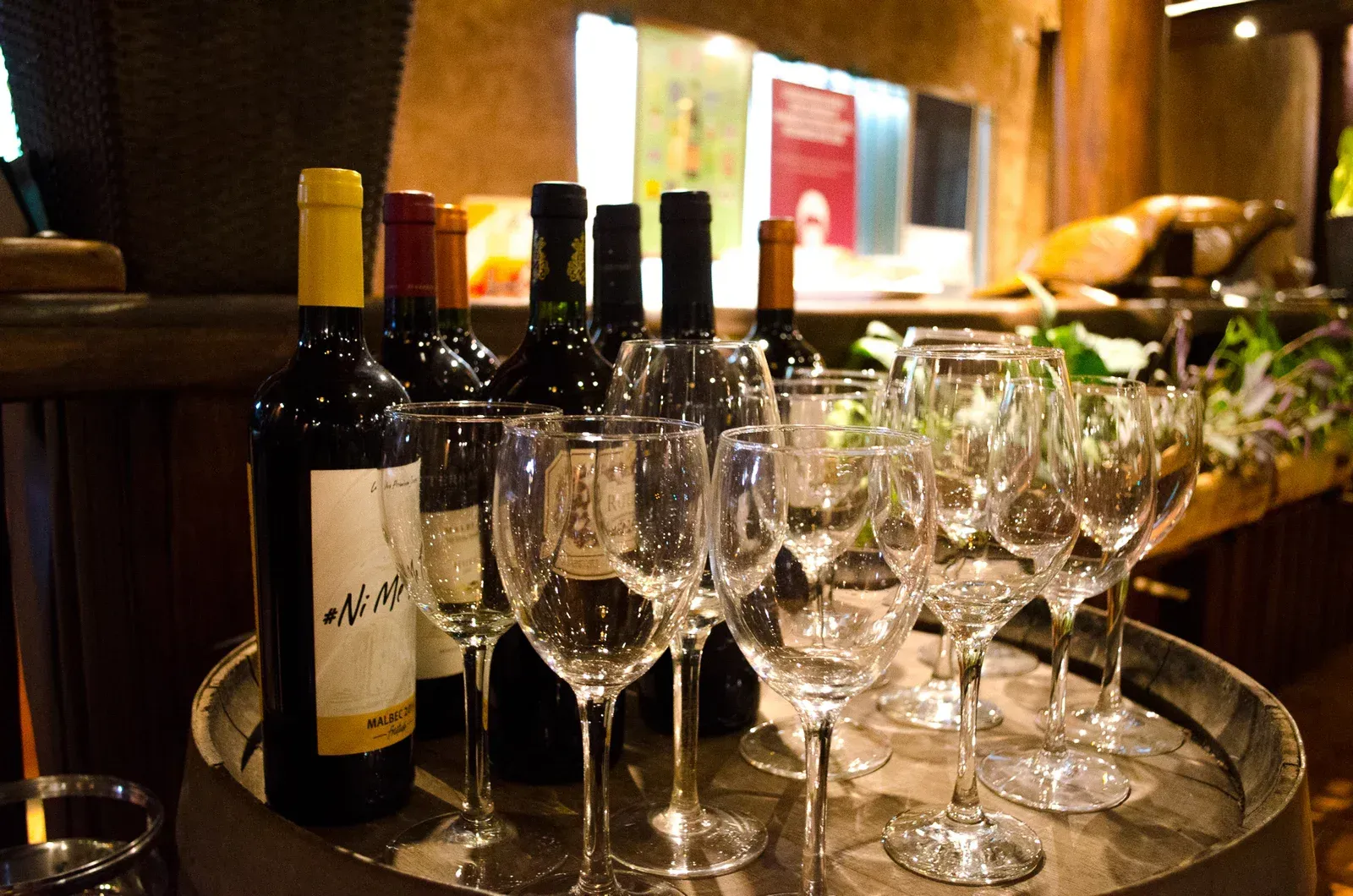 Un montón de botellas de vino y copas de vino en un barril.