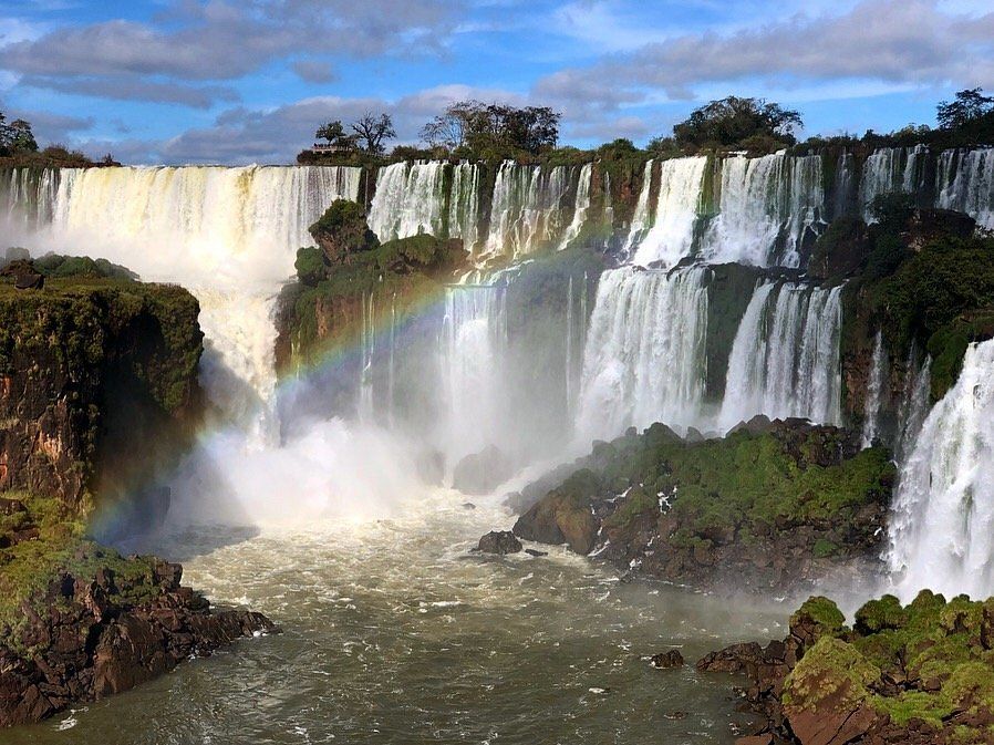 Una cascada con un arco iris en el medio.