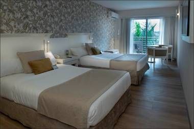 Una habitación de hotel con dos camas y balcón.