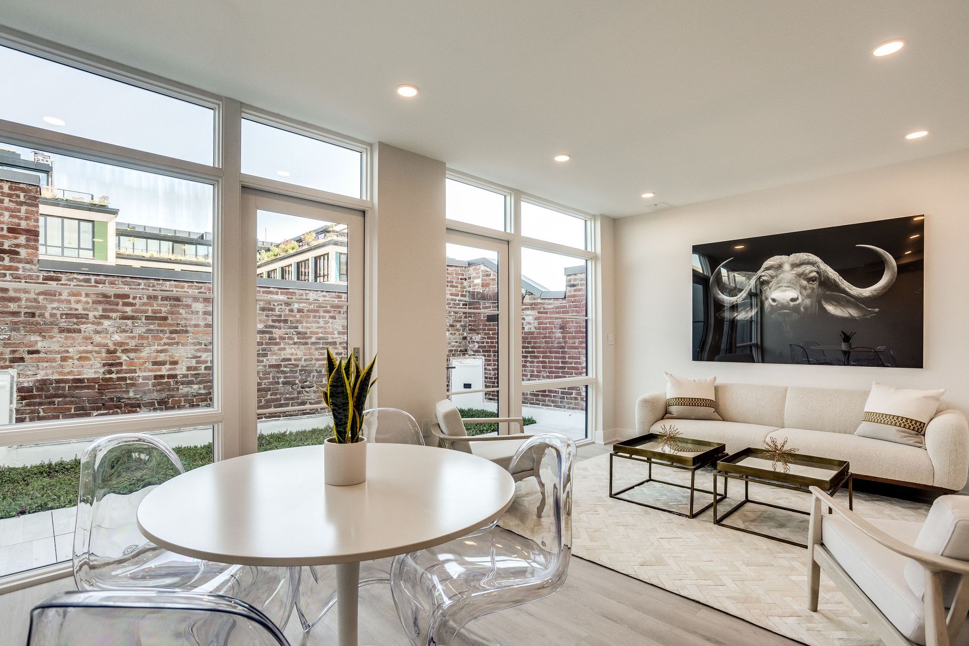 A living room with a couch , table , chairs and a painting on the wall.
