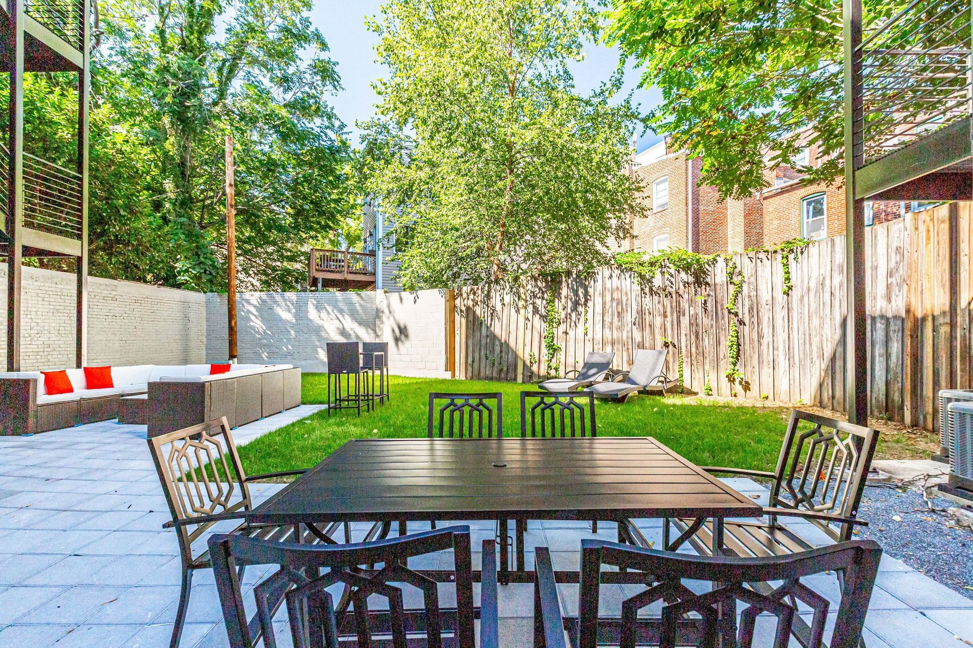 There is a table and chairs in the backyard of a house.