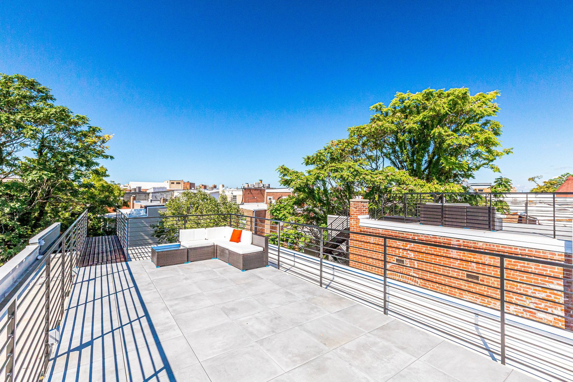 There is a rooftop deck with a couch and chairs on it.