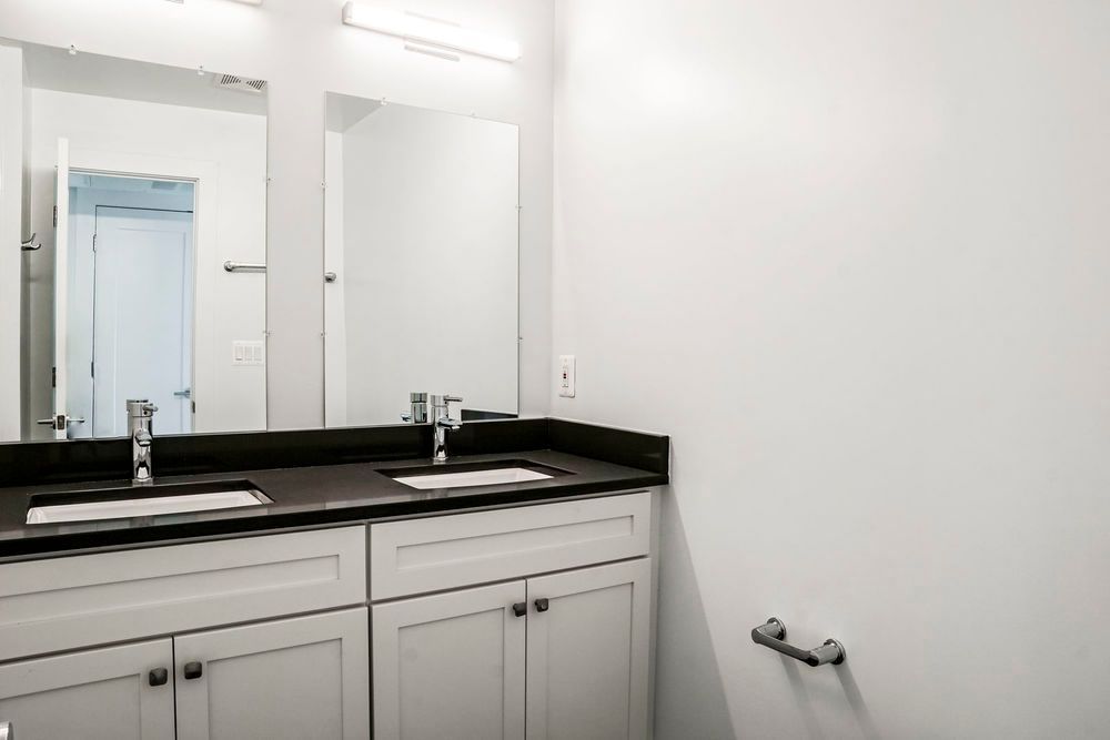 A bathroom with two sinks and a mirror.