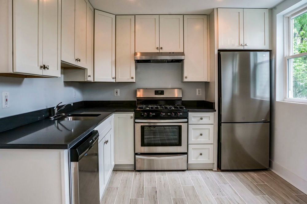 A kitchen with stainless steel appliances and white cabinets