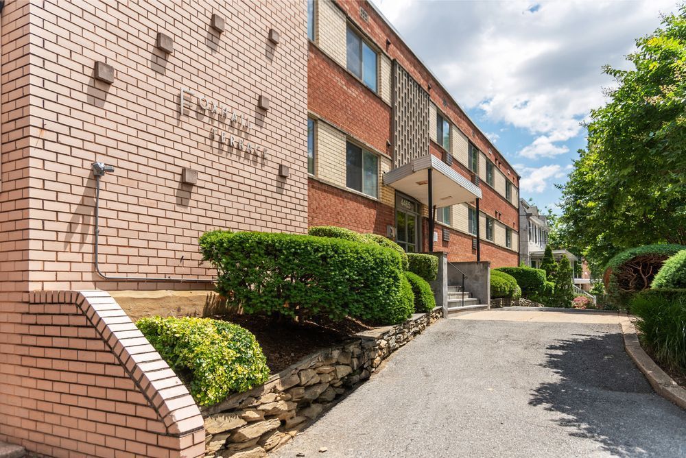 A large brick building with a driveway leading to it.