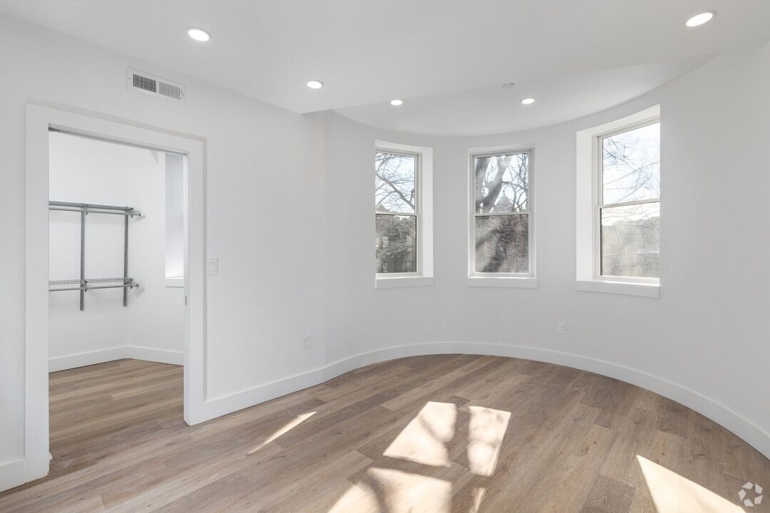 An empty room with hardwood floors and white walls