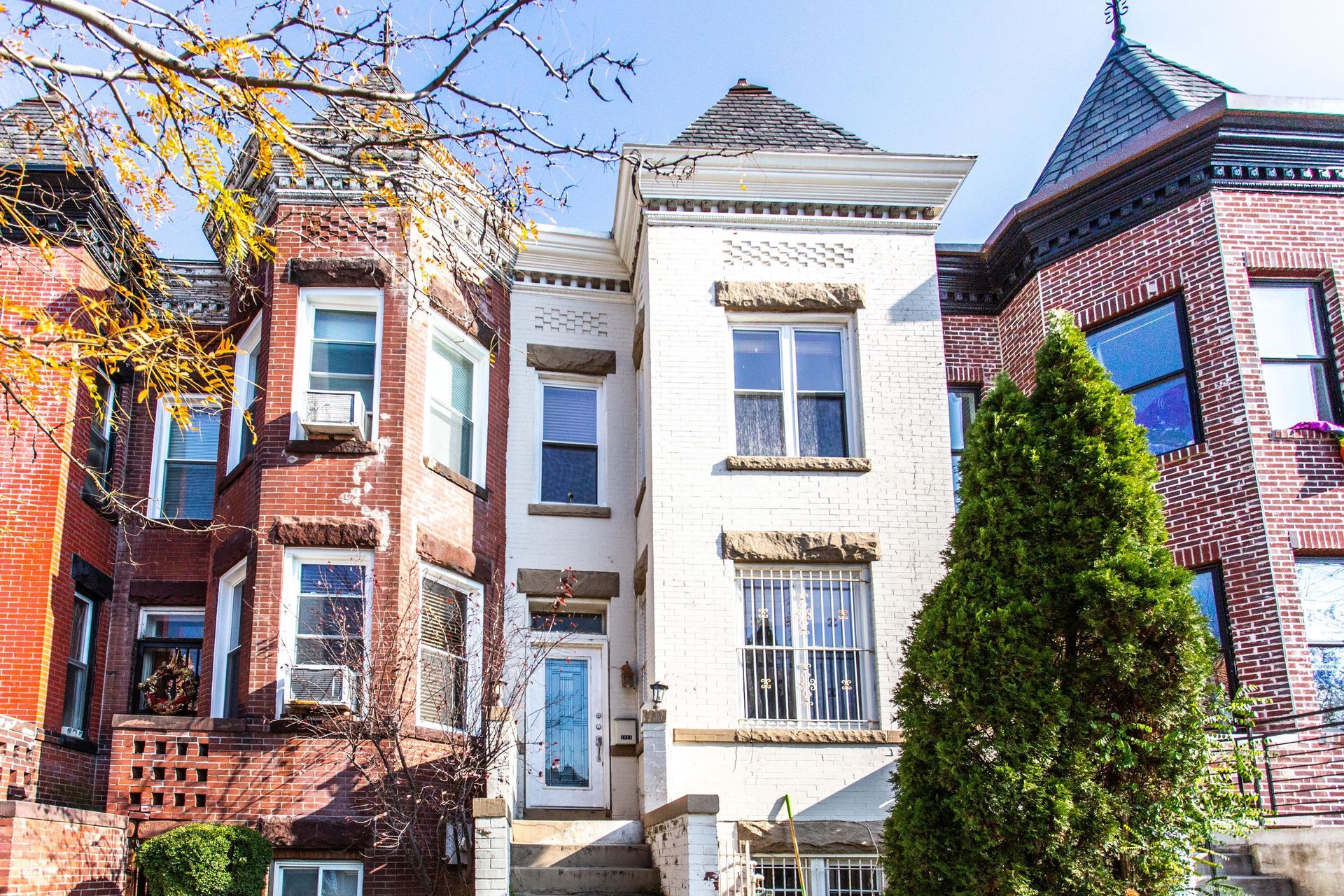 A row of brick buildings with a white building in the middle
