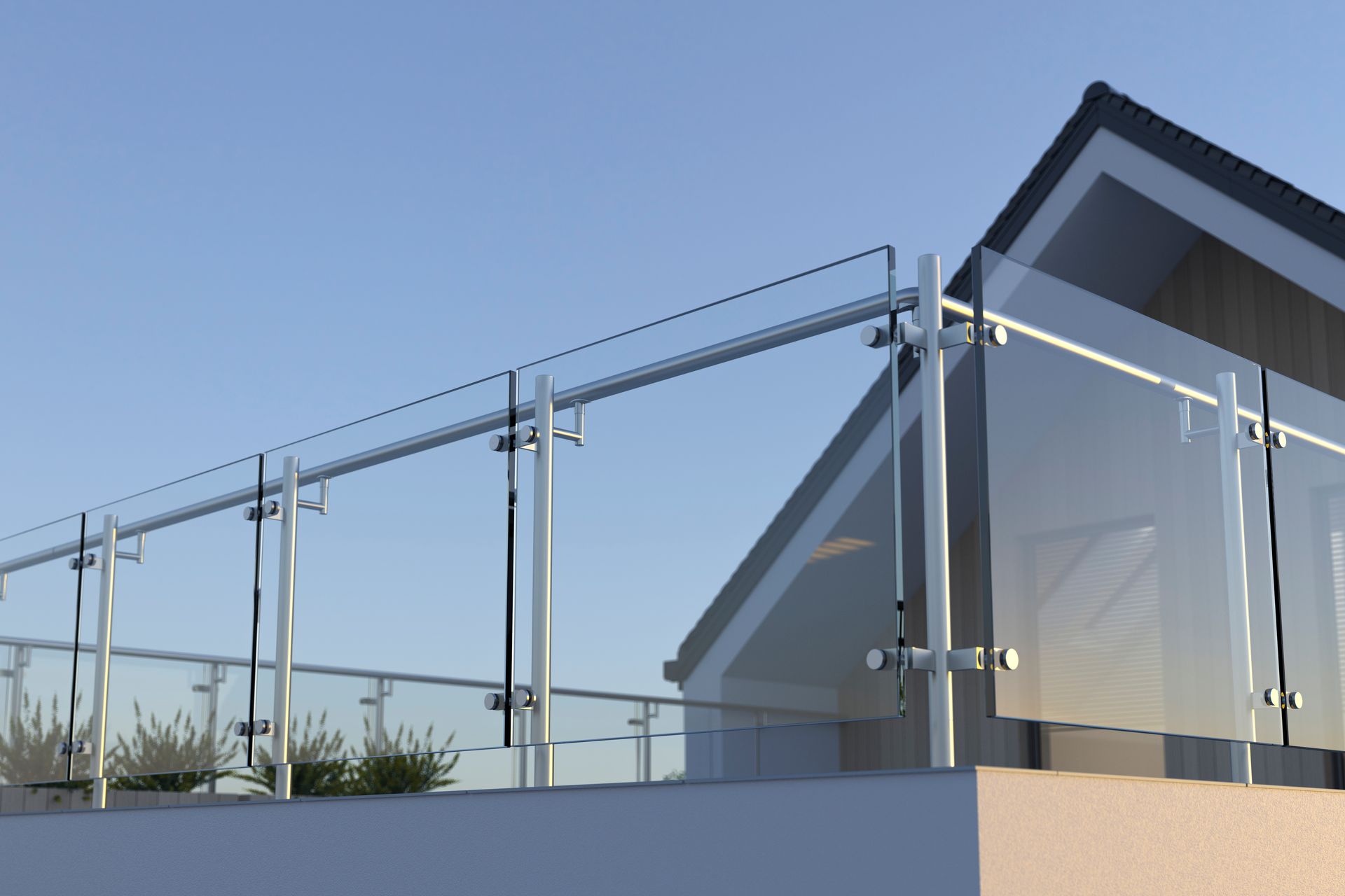 Glass railing on a rooftop with a partial view of a gray roof and blue sky.