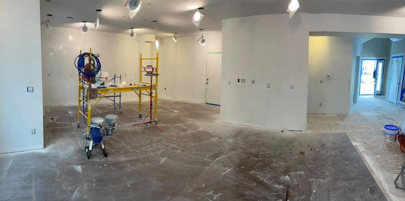 A room being renovated with white walls and construction equipment.