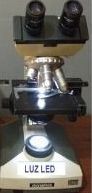 Un microscopio binocular con luz LED. La luz está encendida y la palabra 