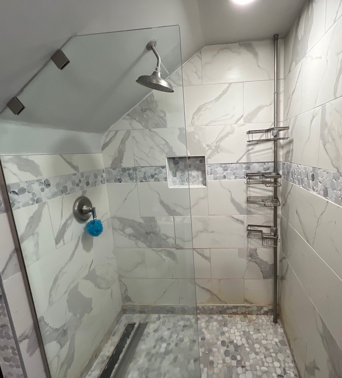 A bathroom with marble tiles and a walk in shower