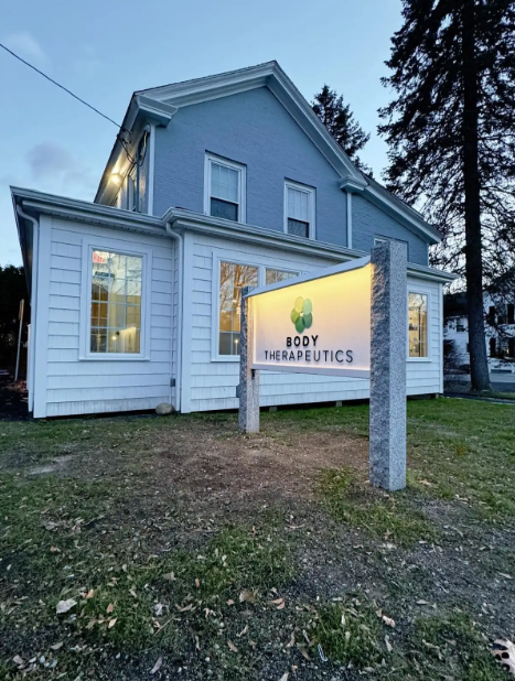 Electrical outlet with burn marks and exposed wiring on a beige wall.