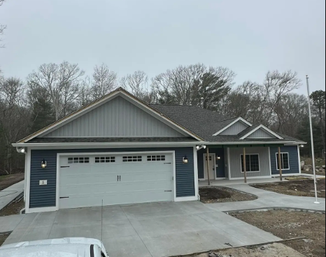 Hand testing an electrical outlet with red and black probes. Wires are visible, wall is white.