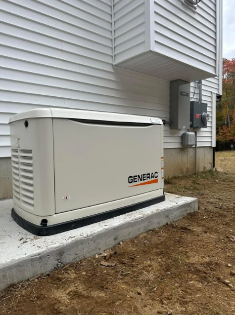 A Generac generator outside a white house, on a concrete pad. Orange text on the generator. Electrical box visible.