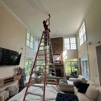 Person installing a ceiling fan blade, using a screwdriver.