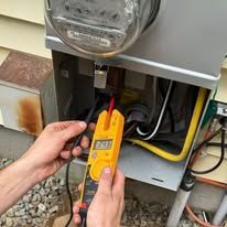 Man installing electrical outlet, kneeling on floor, tools visible.