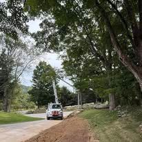 Lineman in orange safety gear repairs power lines from a bucket lift.