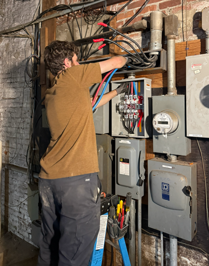 White GFCI electrical outlet with red reset button on a textured wall.