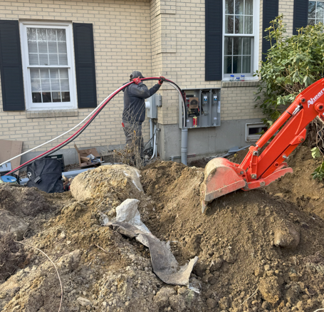 White GFCI electrical outlet with red reset button on a textured wall.