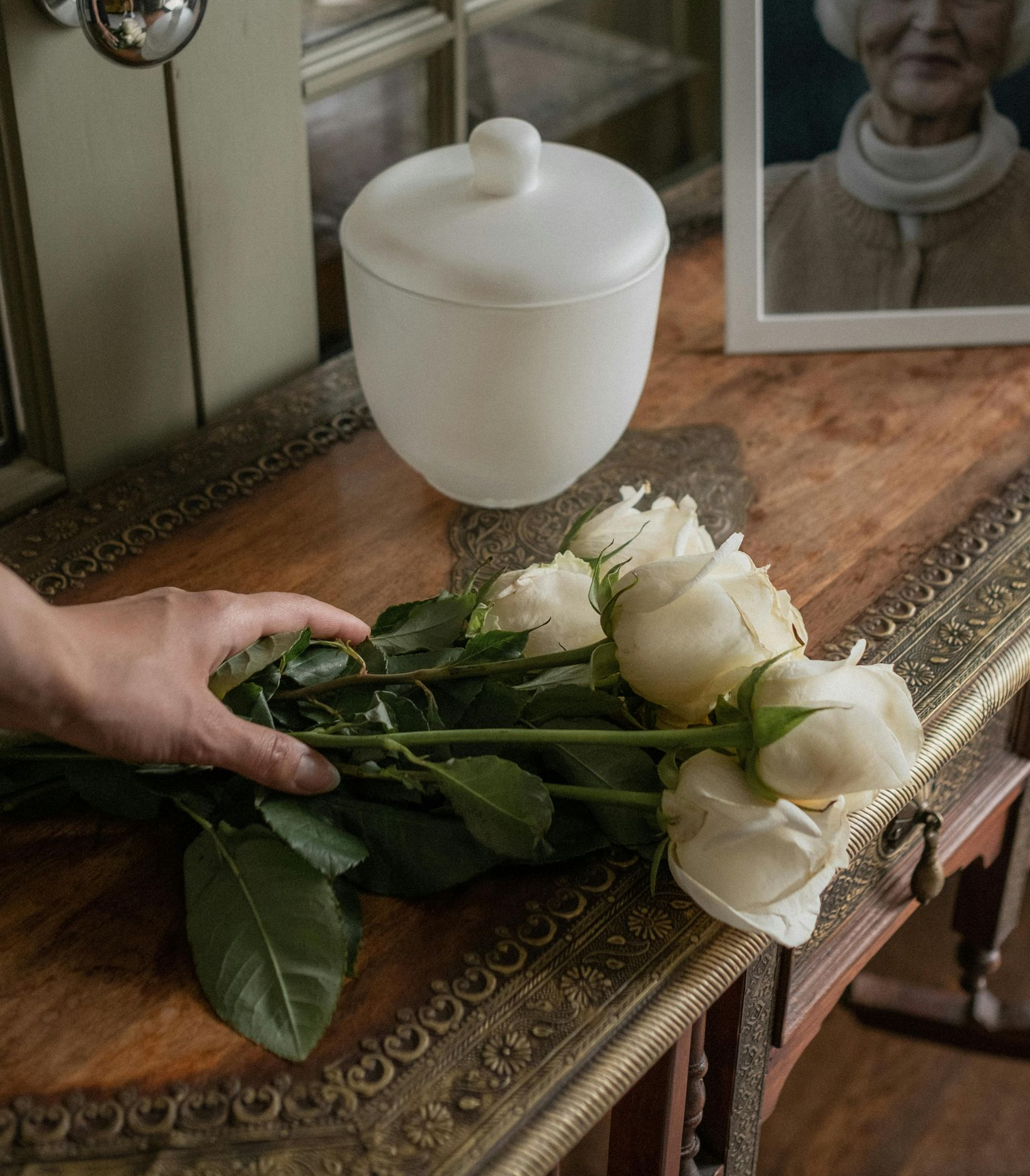 Moderna casa bianca con tetto spiovente, prato e un'auto parcheggiata davanti.