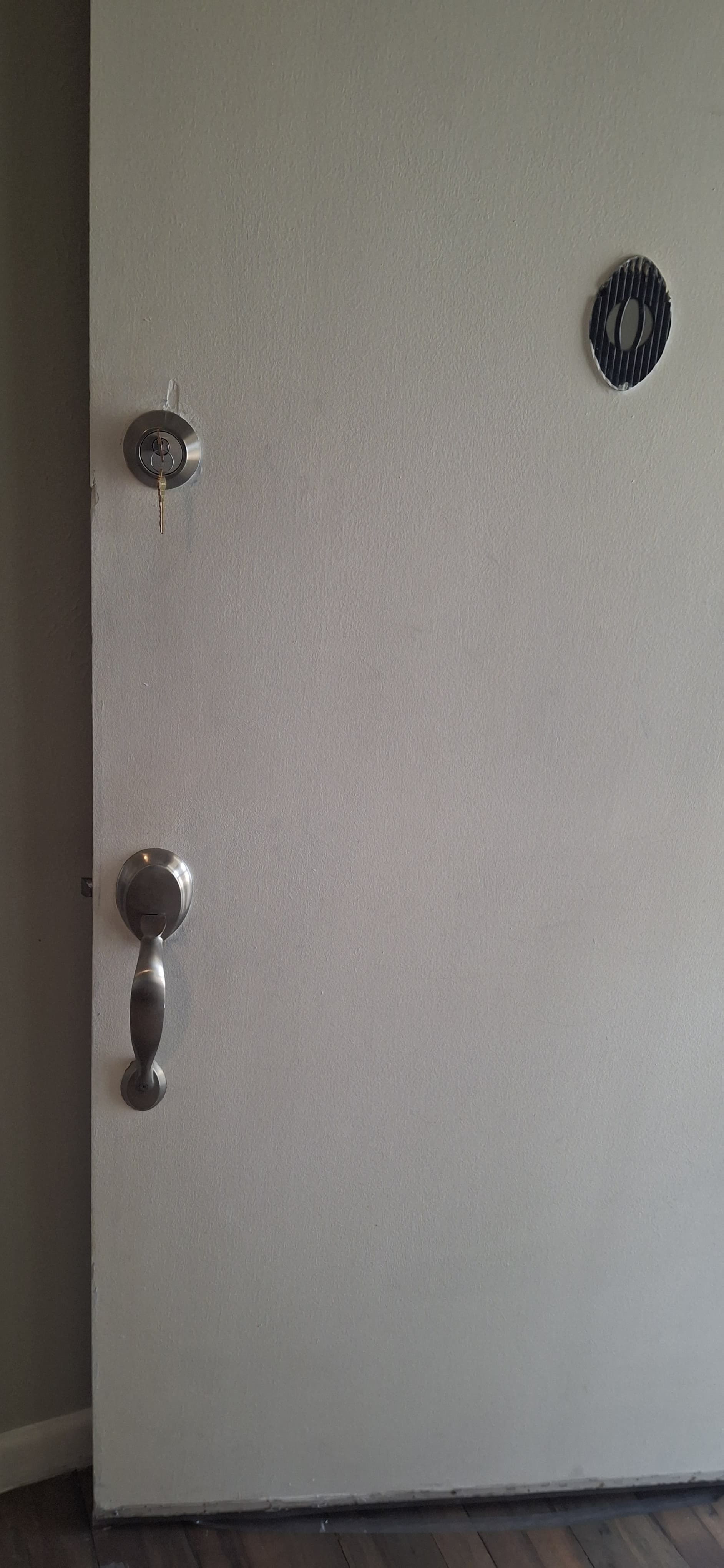 A light-colored bank vault door with a handle, lock, and emblem.