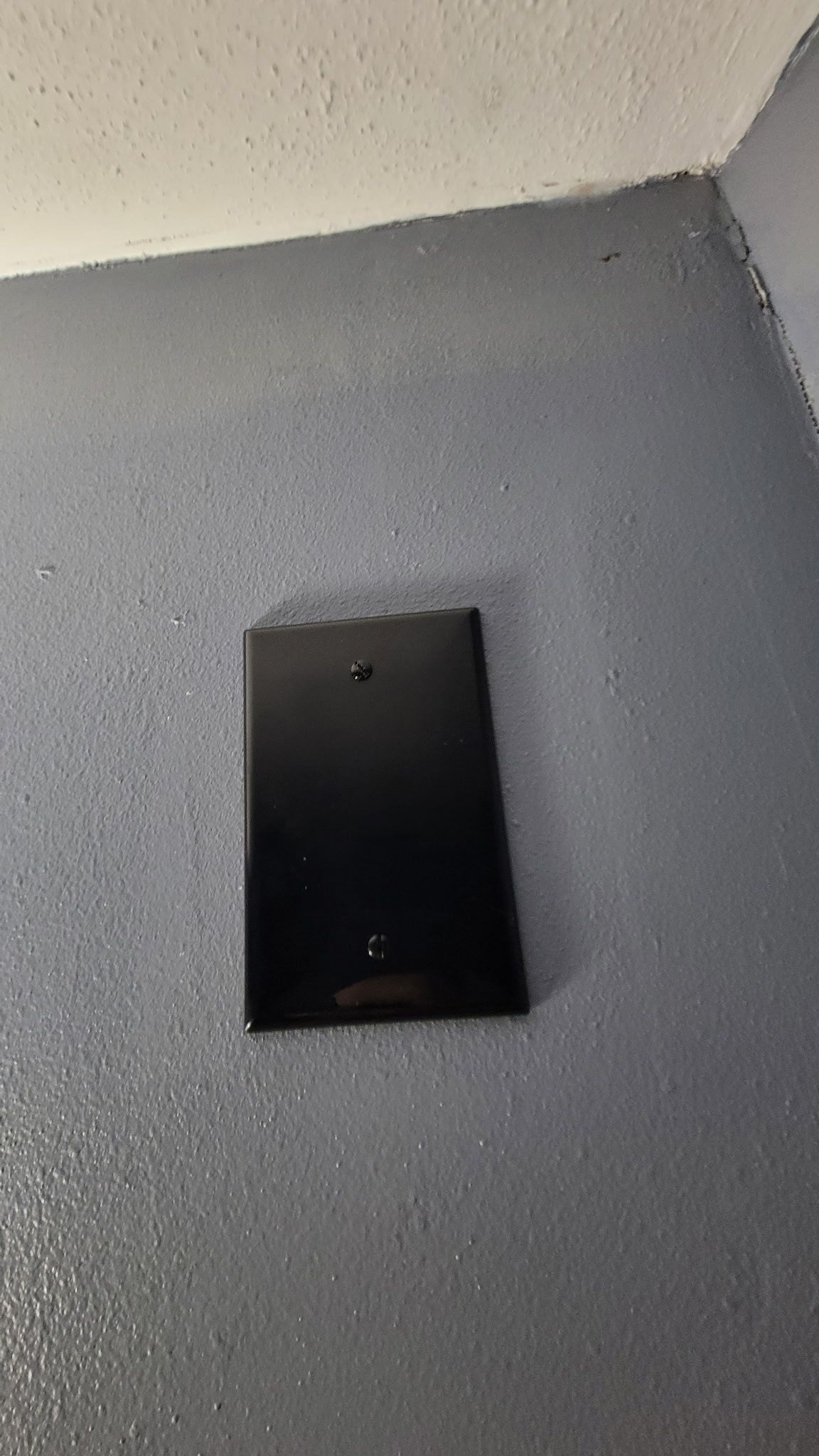 Black rectangular panel on a textured gray surface.